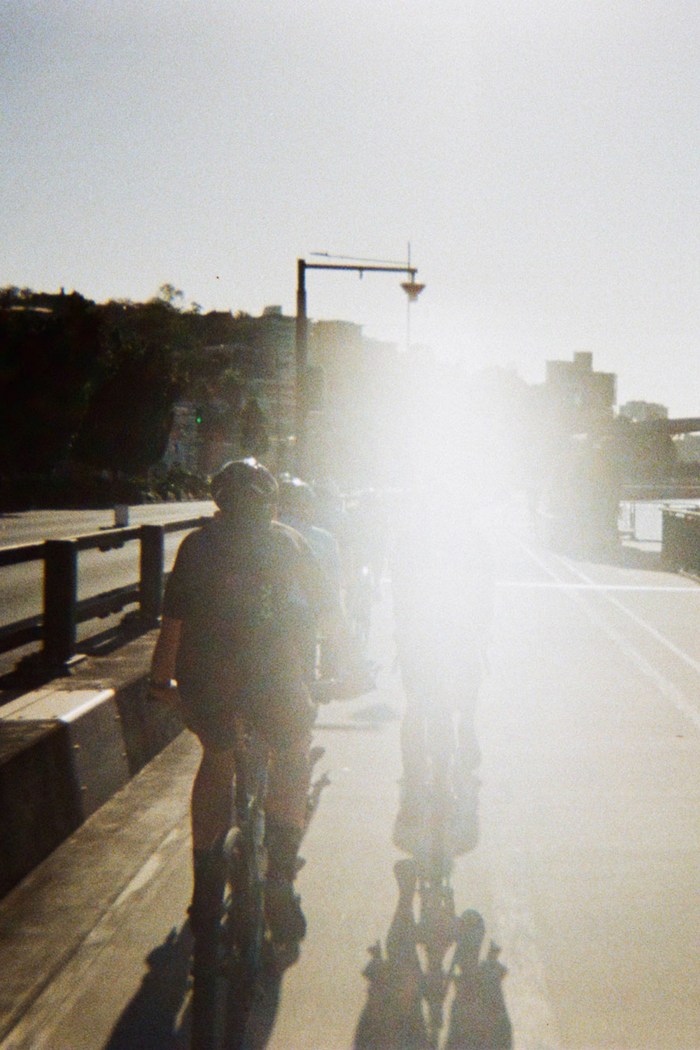 Cyclists riding through bright morning light